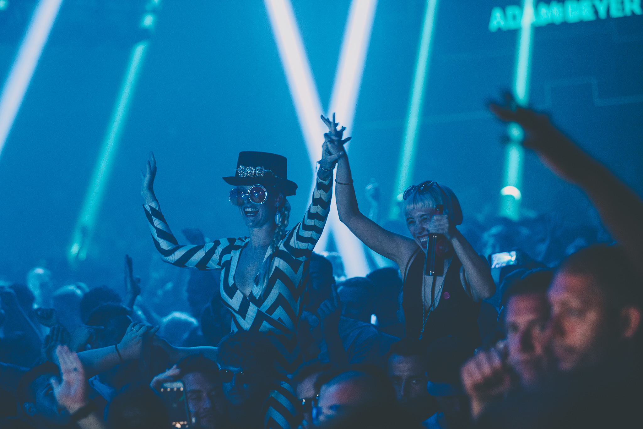 Crowd celebrating at a PURE Carl Cox event with blue stage lights